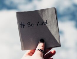 Person holding note that says "be kind" for kindness week
