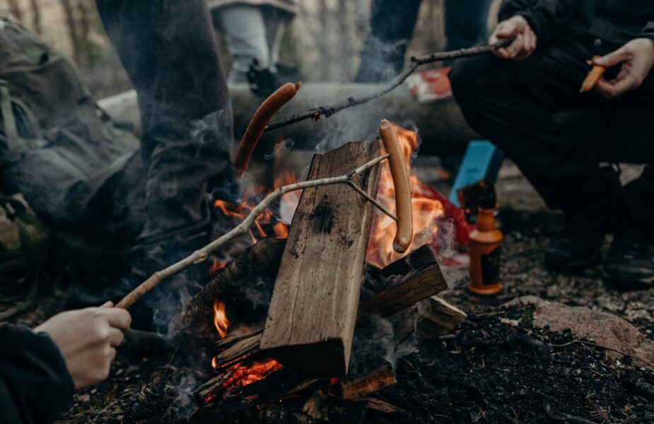 People roasting hot dogs over a fire