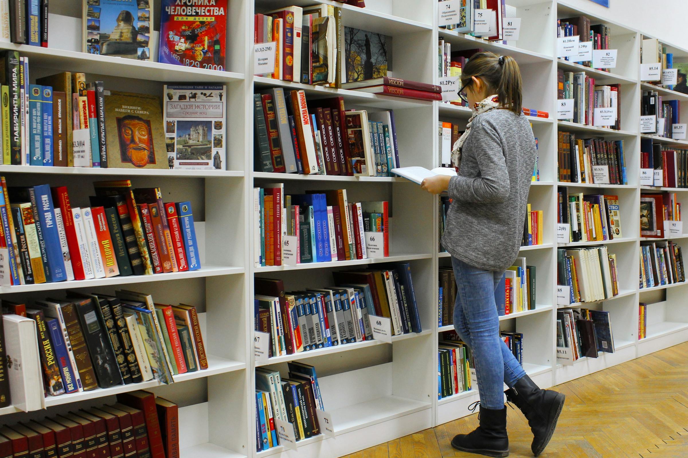 Woman looking through books in a library
