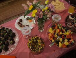 Table with Galentine treats and pink table cloth and flowers