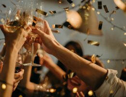 People holding champagne glasses with confetti in the air