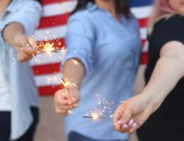 Closeup of three people holding sparklers for the fourth of july