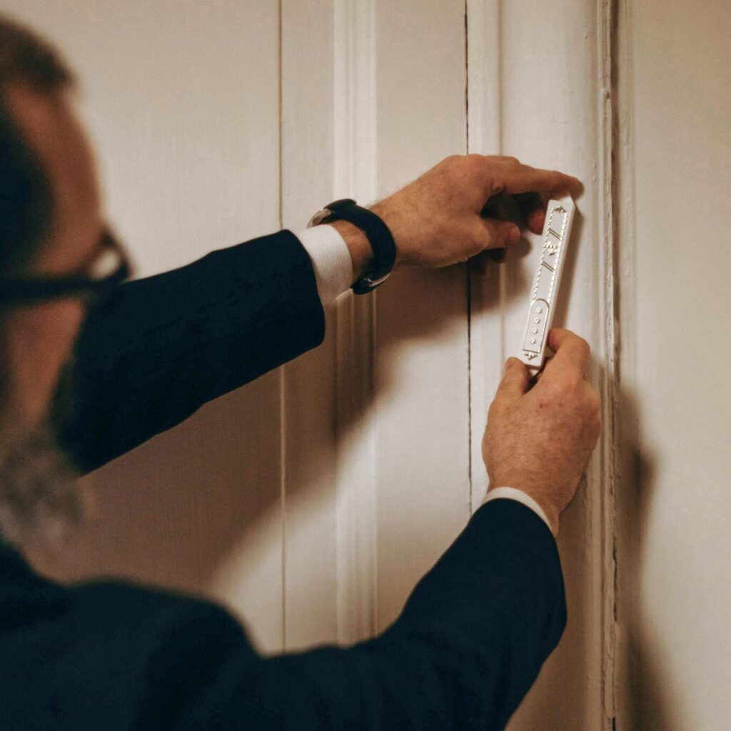 Person hanging a Mezuzah