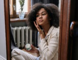 Woman looking in mirror using skin ca